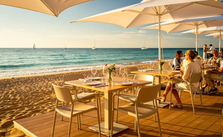 Un restaurant de plage élégant avec des parasols blancs et des tables sur le sable de Saint-Cyr-sur-Mer, face à la mer turquoise.