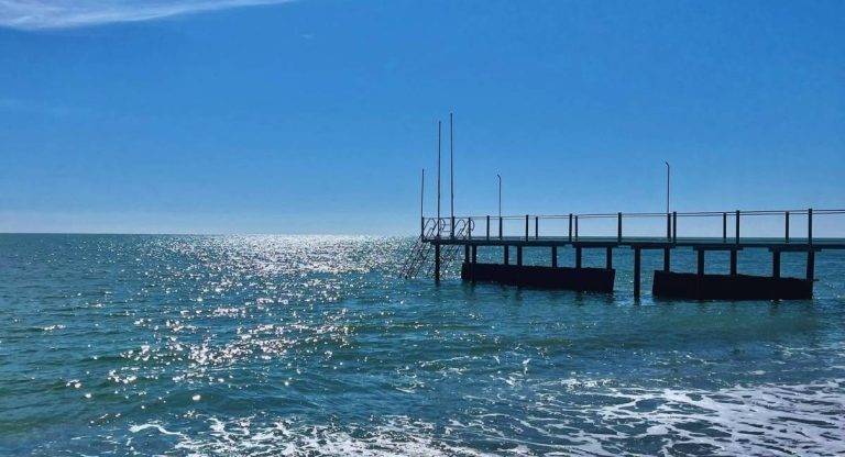 Ponton en bois s'étendant sur une mer méditerranéenne calme par temps ensoleillé