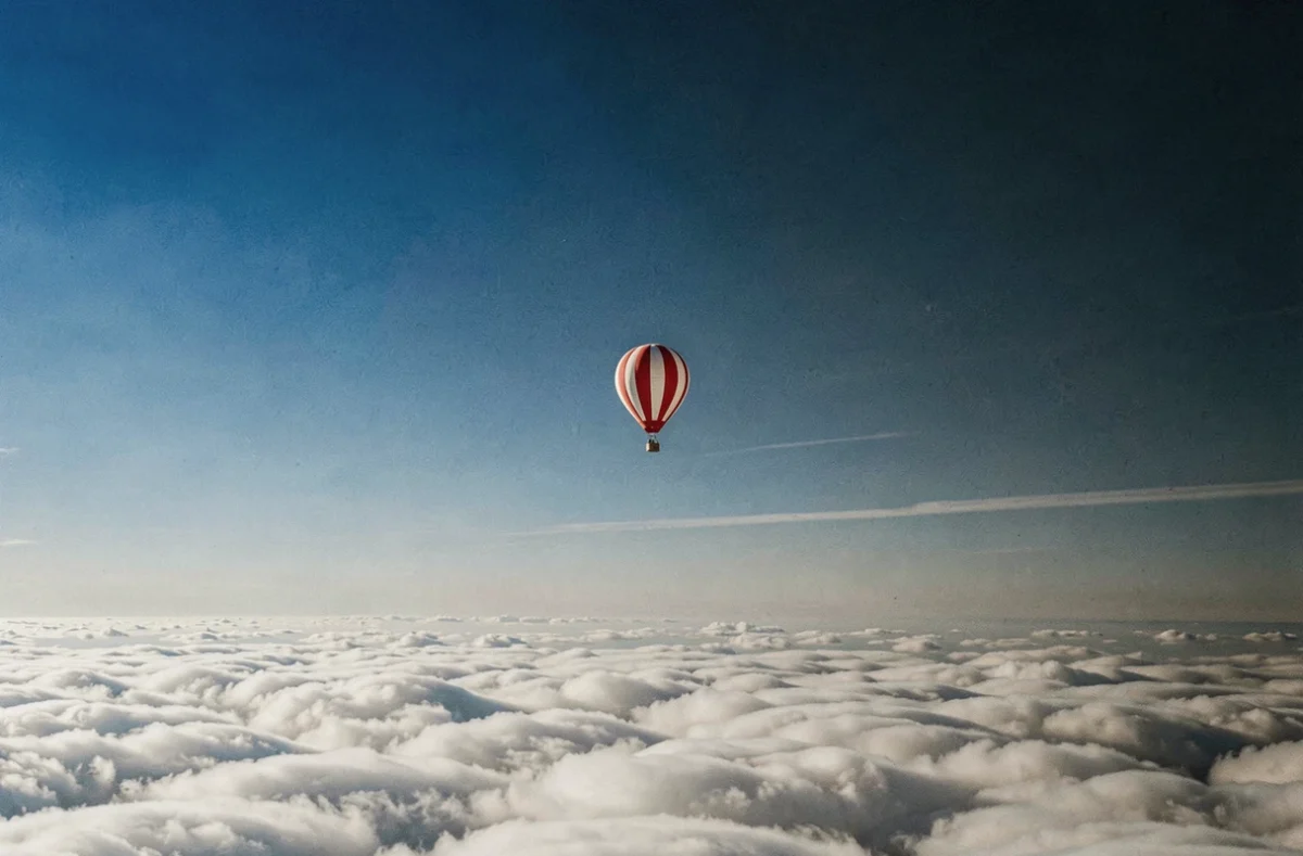 Montgolfière en altitude au-dessus des nuages dans un ciel bleu profond illustrant la hauteur maximale atteignable